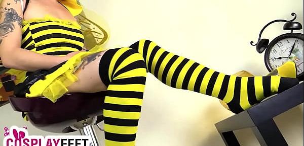  Cosplayer in bee costume shows feet in striped stockings